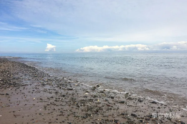 高清摄影 白天蓝天下的海浪拍打着岸边。