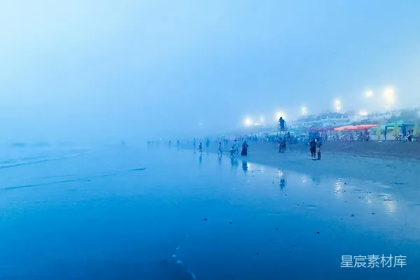 高清摄影 一群人在雾气弥漫的海滩上行走。