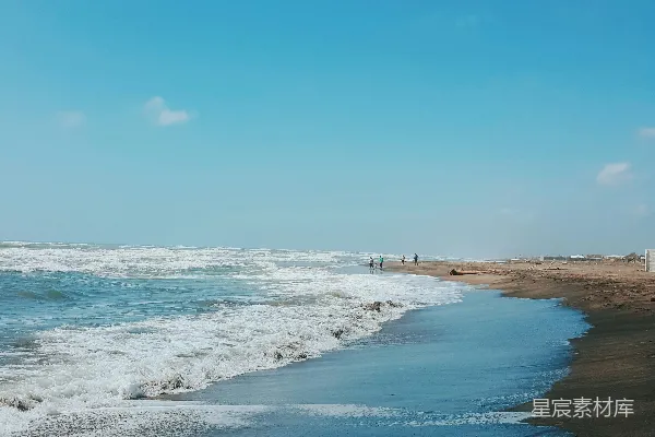 高清摄影 一个沙滩，海浪拍打着岸边。