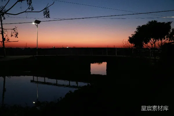 高清摄影 夕阳为黑暗的池塘上方的天空涂上了一抹色彩。