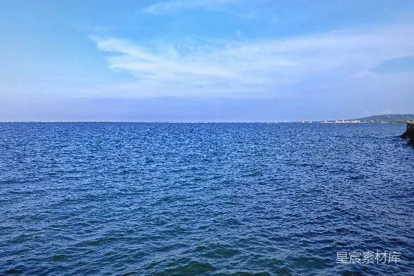 高清摄影 白天蓝天下的水边棕色岩石