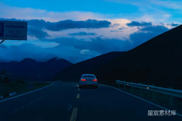 高清摄影 一辆车在道路上行驶，背景是山脉。