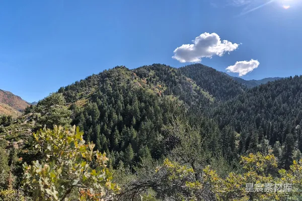 高清摄影 一幅山峦的美景图，前景中树木葱翠。