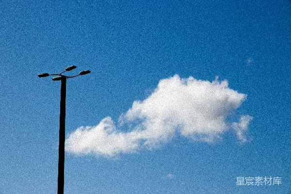 高清摄影 路灯映衬在明亮的蓝色天空下，天空中有云彩。