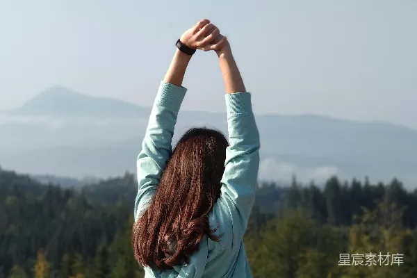 高清摄影 穿着深蓝长袖上衣的女子站在山顶白天 daytime站立在山顶上的女子穿着一件长袖的浅蓝色衣服