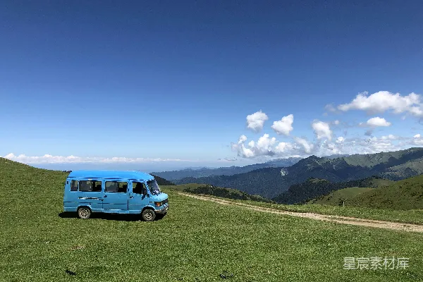 高清摄影 白天，蓝色货车停在绿草地上。