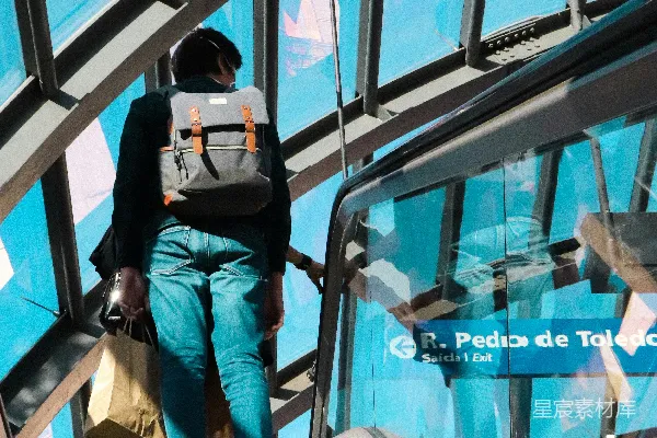 高清摄影 一个男人正沿着建筑物中的自动扶梯往下走。