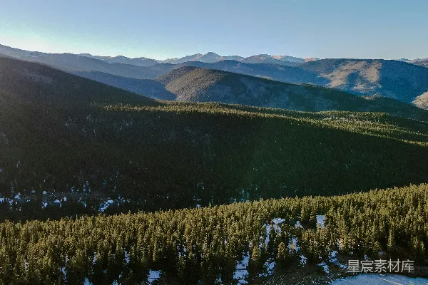 高清摄影 一幅山峦连绵的景色，前景中是树木。