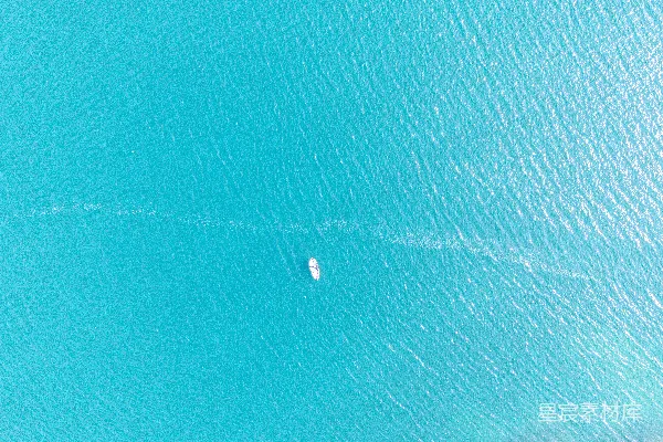 高清摄影 一架飞机俯瞰一艘停泊在碧绿海水中的船只。