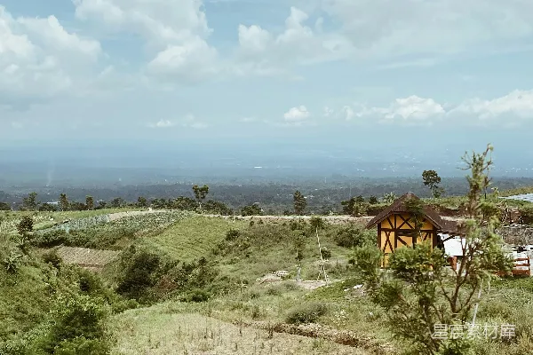 高清摄影 一片草地，远处有一间小屋。