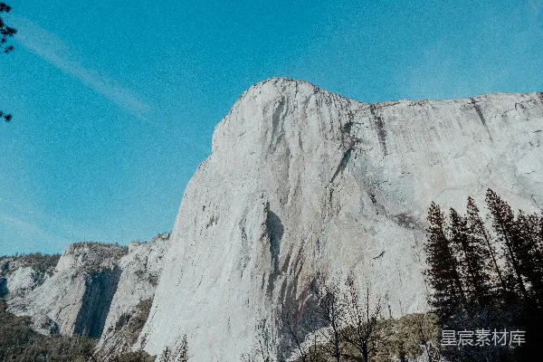高清摄影 一座山的景色，前景中有树木。