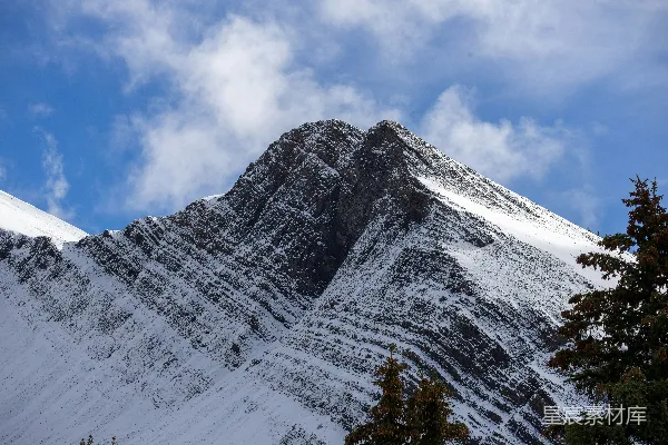 高清摄影 白雪覆盖的山峰在阴云密布的蓝天下。
