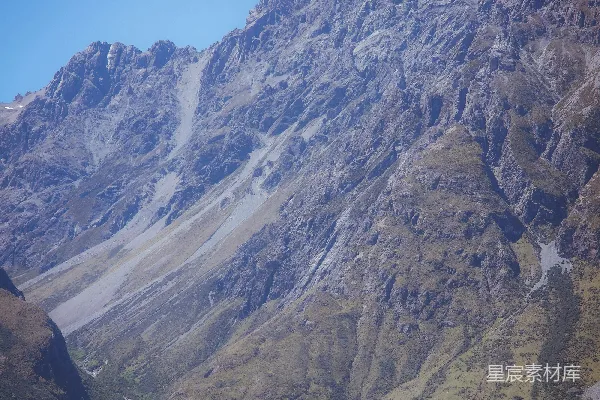 高清摄影 一片绿草如茵的田野，背景是一座山。