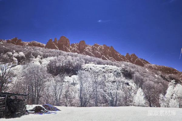 高清摄影 一片覆盖着积雪的田野，背景是一座山脉。