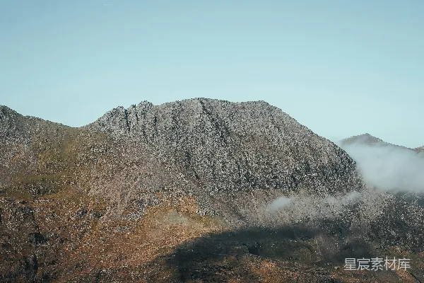 高清摄影 一座山脉的景象，山脚下弥漫着低垂的云雾。