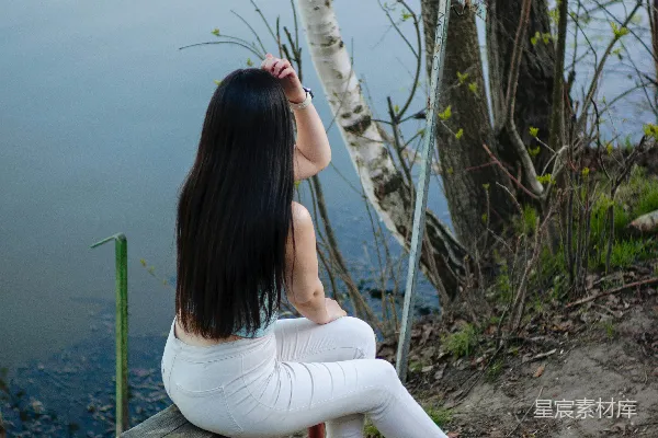 高清摄影 女人坐在长椅上，凝视着水面。