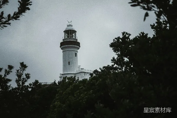 高清摄影 一盏黑白相间的灯塔，周围环绕着树木。