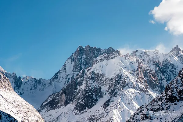 高清摄影 被积雪覆盖的山脉在阴云密布的蓝天之下