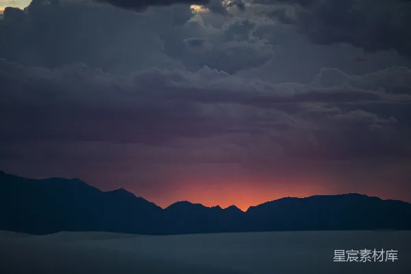 高清摄影 夕阳西下，云层低垂，山影轮廓分明。