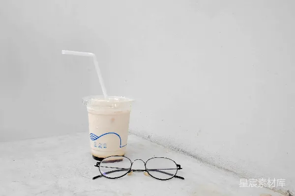 高清摄影 黑色镜框的眼镜放在一个白色的一次性杯子旁边。