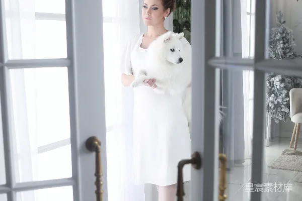 高清摄影 一位穿着白裙的女人抱着一只白泰迪熊。