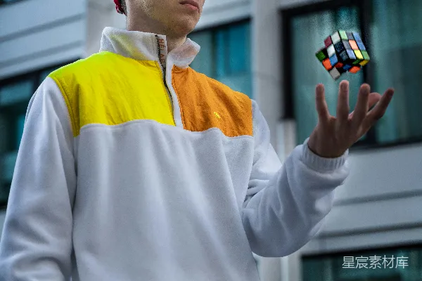 高清摄影 穿白色和黄色长袖衬衫的男人手里拿着一个黑白相间的陶瓷水杯。