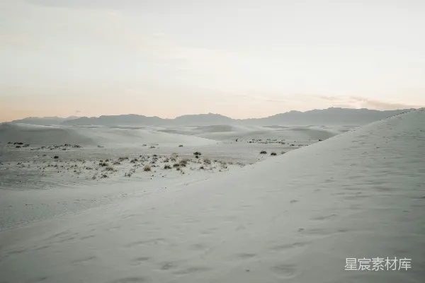 高清摄影 一片被雪覆盖的田野，背景中有山脉。