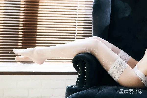 高清摄影 一个穿着白色内衣的女人坐在一把黑色椅子上。
