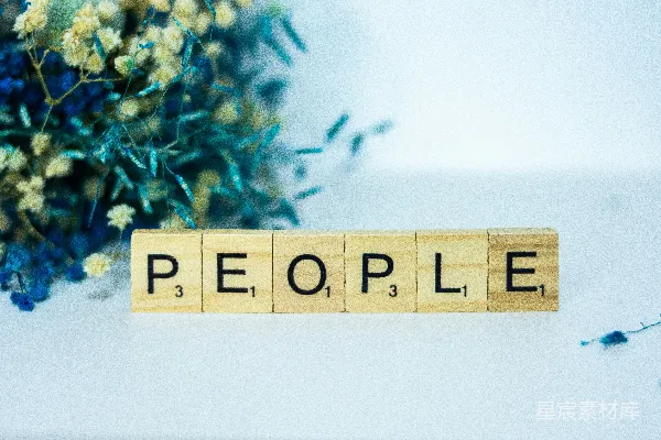 高清摄影 一个拼出“people”的木块旁边有一束花。