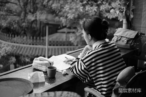 高清摄影 女人在宁静的场景中靠窗写作。