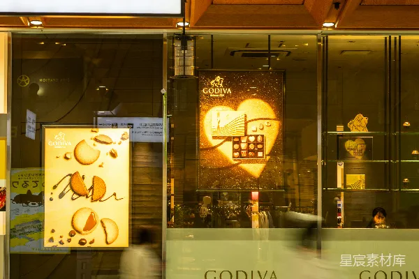 高清摄影 人们走过一家歌帝梵巧克力店。
