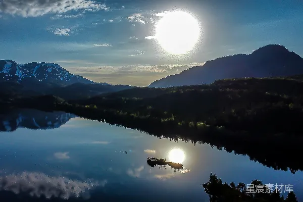 高清摄影 一轮满月悬挂在湖上，背景中有连绵的山脉。