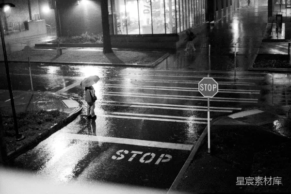 高清摄影 一个雨夜，有人行道上的行人停下了脚步。