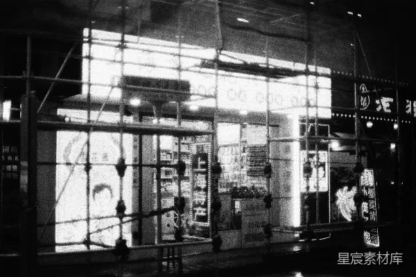 高清摄影 一个灯光通明的店面被脚手架包围着。