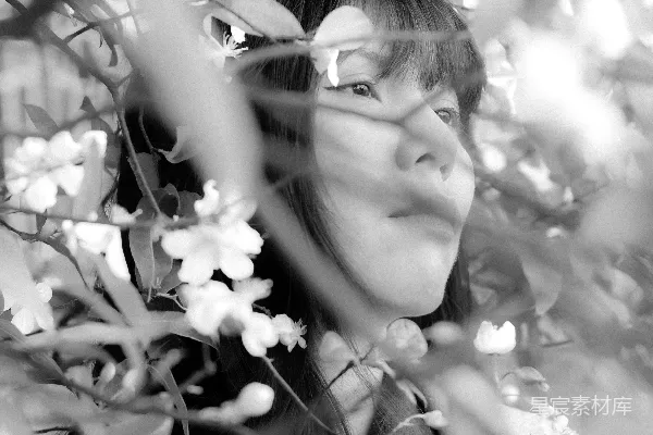 高清摄影 女人通过黑白的花朵凝视。