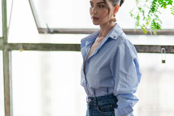 高清摄影 穿蓝色衬衫的女人靠在窗边摆姿势。