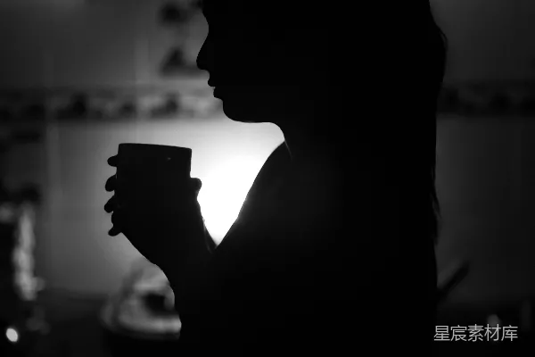高清摄影 一个女人剪影，手里拿着一杯咖啡。