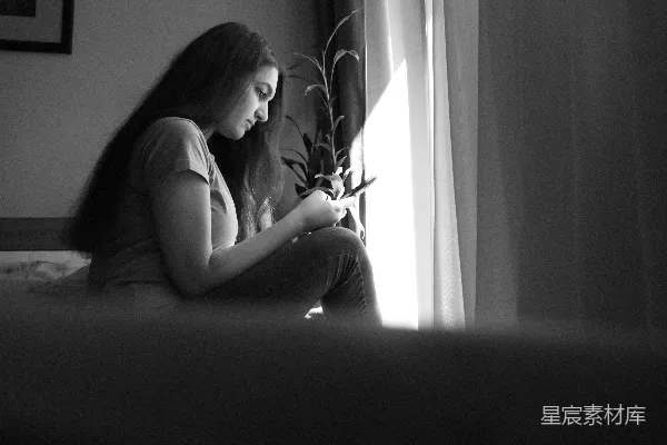 高清摄影 一个女人坐在窗边的床上