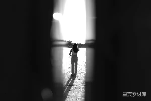 高清摄影 一个人站在房间里，有光线透过窗户照进来。