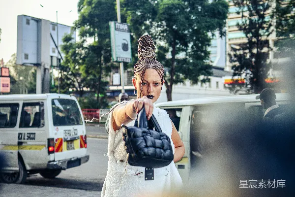 高清摄影 穿着白色连衣裙的女人拿着一只黑色手套