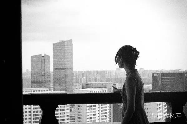 高清摄影 女人正望着窗外的城市天际线。