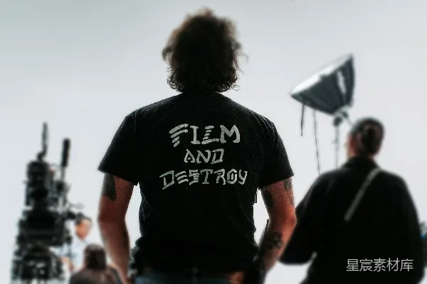 高清摄影 一名导演站在拍摄现场，胸前的衬衫上写着“film and destroy”。