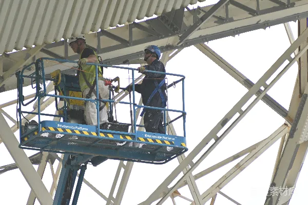 高清摄影 工人使用升降机在建筑物上工作。