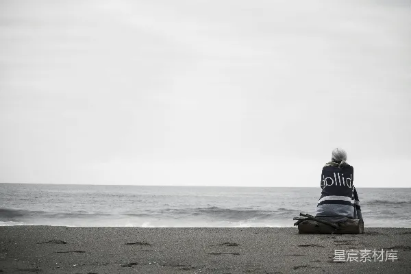 高清摄影 白天，一位女性坐在海边。
