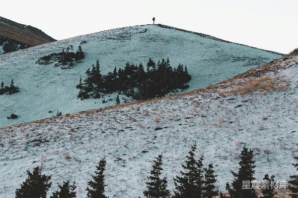 高清摄影 一个孤独的身影站在白雪皑皑的山顶。