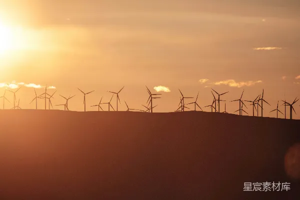 高清摄影 风力发电机在夕阳的映衬下剪影般矗立。