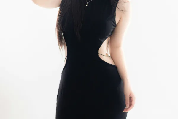 高清摄影 一位女士穿着一件流线型的黑色连衣裙摆姿势。