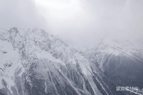 高清摄影 覆盖着积雪的山脉在阴沉的天空下若隐若现。