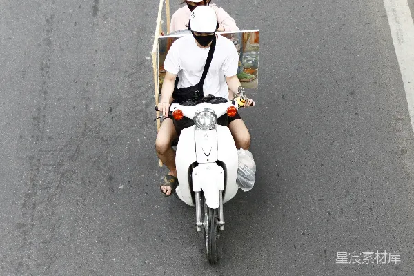高清摄影 两个人骑着一辆带拖车的滑板车。