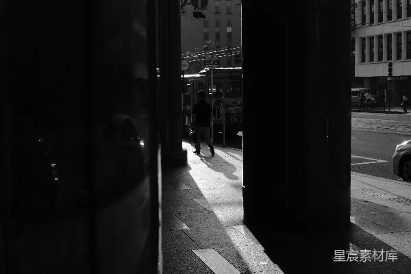 高清摄影 人们在阳光明媚的城市人行道上行走，建筑物之间。